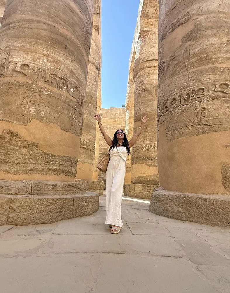 Woman with raised arms among columns